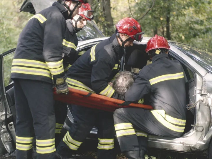 Rescue crew helping a driver out of a wrecked car