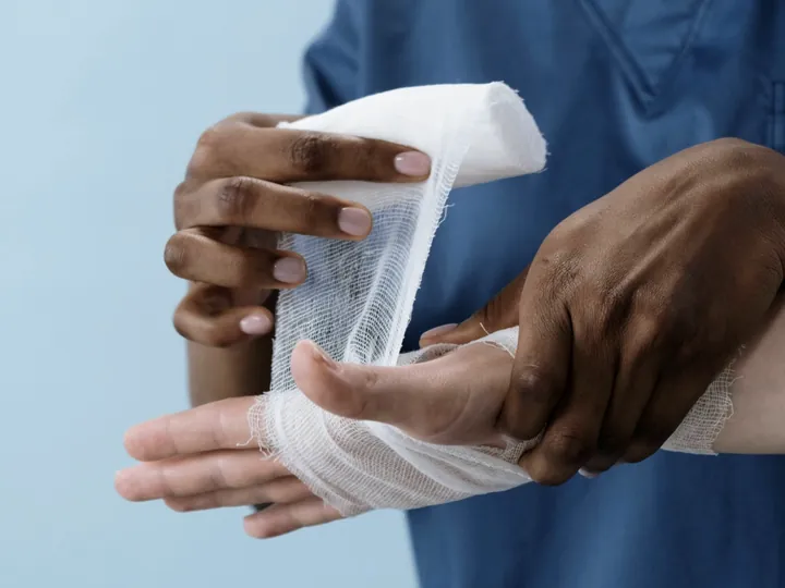 Medical worker bandaging an injured hand